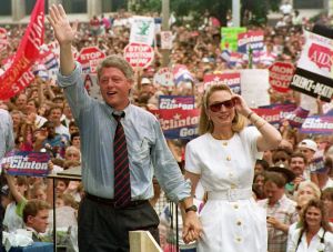ST. LOUIS, UNITED STATES: Democratic presidential candidate Bill Clinton (L) waves to supporters as he holds the hand of his wife Hillary, 22 July, 1992 after speaking at a rally. St. Louis was the last stop on the Clinton-Gore campaign's bus tour. The crowd was estimated at 40,000. (Photo credit should read TIM CLARY/AFP/Getty Images)